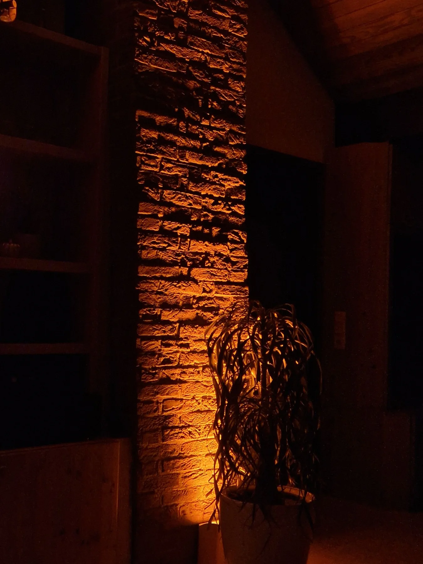 Warmes Uplighting an einer Steinwand